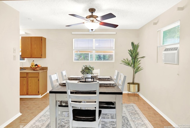 dining area with ceiling fan, a healthy amount of sunlight, sink, and a textured ceiling