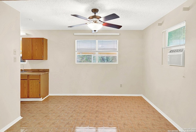 unfurnished room featuring ceiling fan, sink, and a textured ceiling