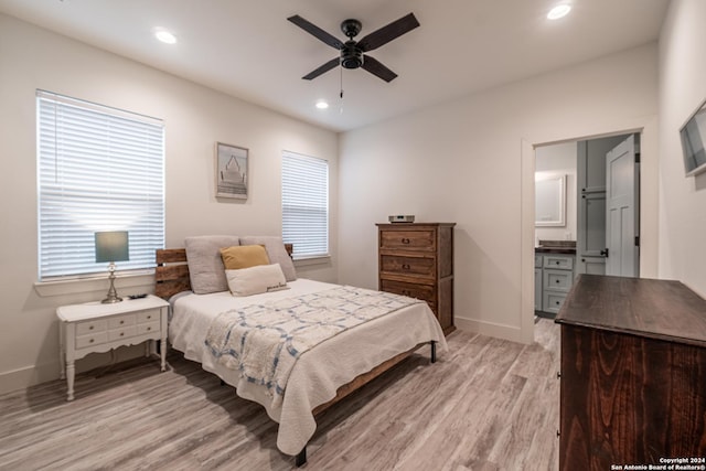 bedroom with ceiling fan, light wood-type flooring, and ensuite bath