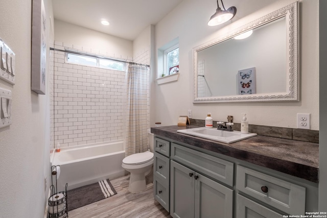 full bathroom featuring hardwood / wood-style floors, vanity, shower / tub combo, and toilet