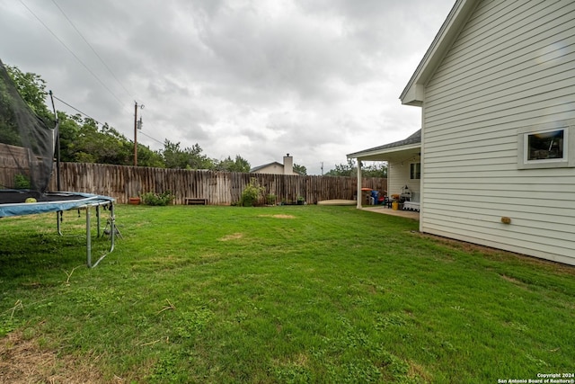 view of yard featuring a trampoline and a patio area