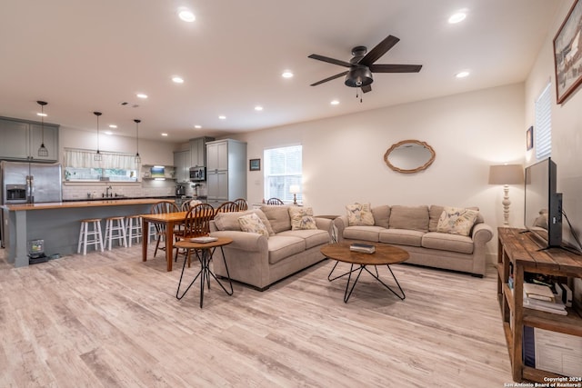 living room featuring ceiling fan and light wood-type flooring