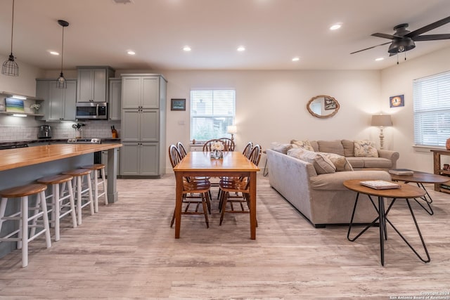 living room with light hardwood / wood-style flooring and ceiling fan