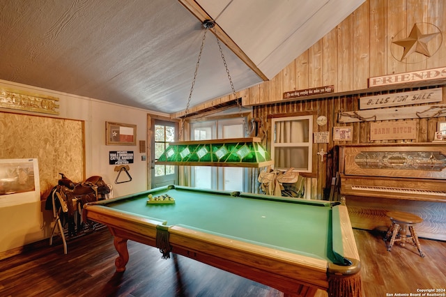 rec room featuring hardwood / wood-style flooring, vaulted ceiling, and wood walls