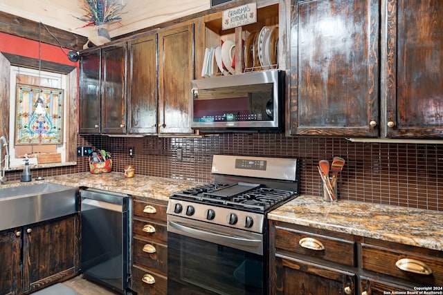 kitchen featuring dark brown cabinetry, light stone counters, pendant lighting, stainless steel appliances, and decorative backsplash