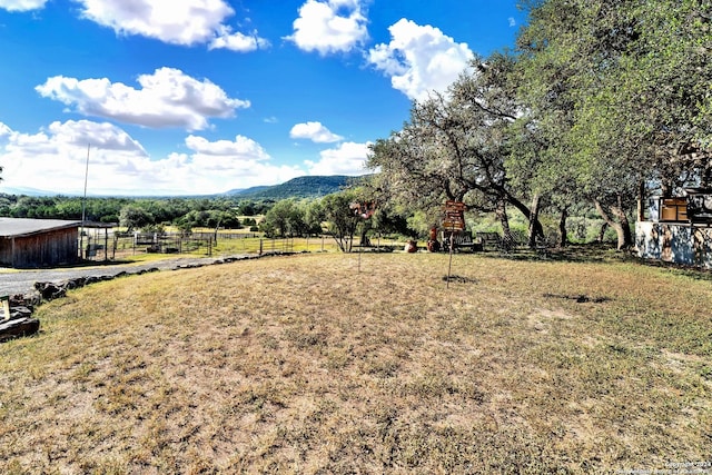 view of yard with a rural view and a mountain view