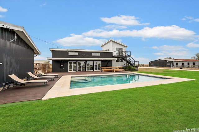 view of pool featuring a lawn and a wooden deck