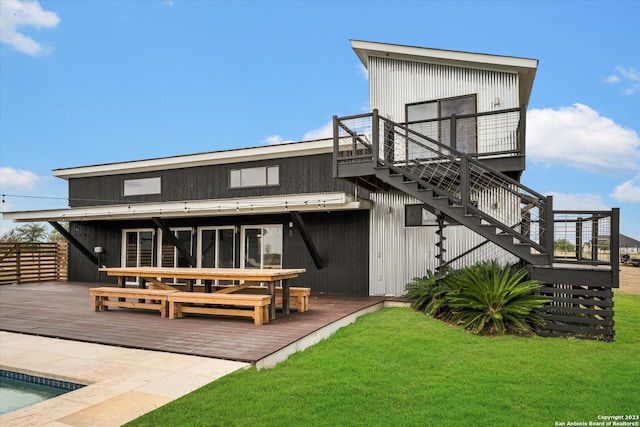 rear view of house with a yard, a swimming pool side deck, and a patio