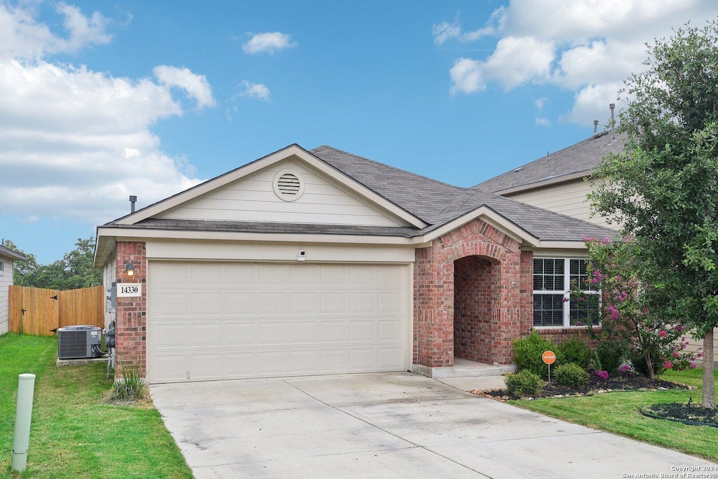 ranch-style home featuring a garage, central air condition unit, and a front lawn