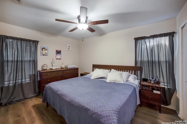 bedroom featuring ceiling fan, wood-type flooring, and a textured ceiling