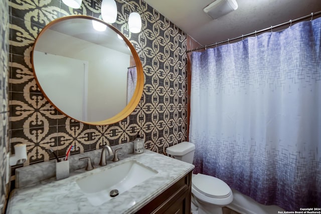 bathroom featuring vanity, toilet, and curtained shower