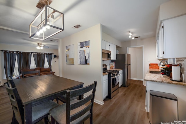 dining area with dark hardwood / wood-style floors, ceiling fan, and sink