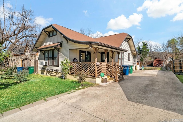 view of front of home featuring cooling unit, covered porch, and a front lawn