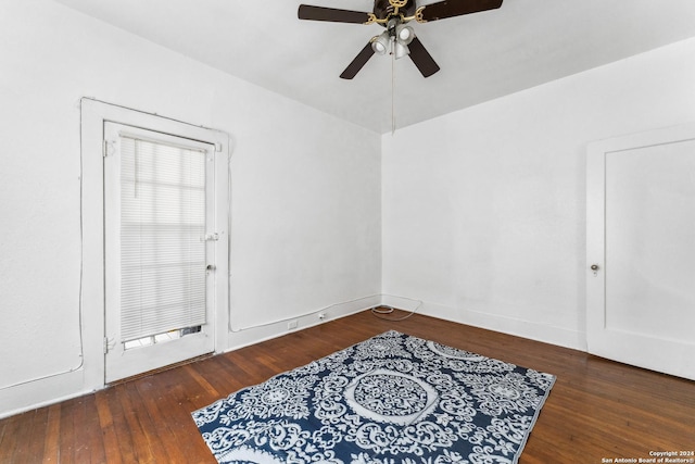 empty room with ceiling fan and dark wood-type flooring