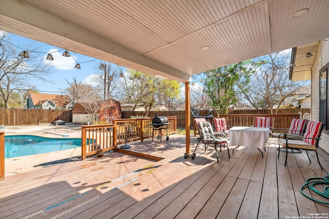 deck featuring a fenced in pool and a storage shed