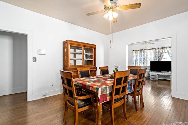 dining space with ceiling fan and dark wood-type flooring