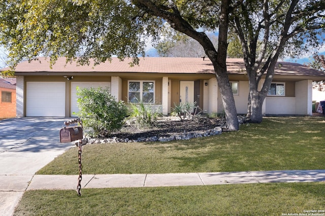 ranch-style home with a garage and a front lawn