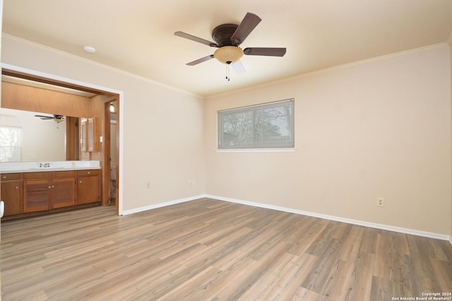 unfurnished bedroom with sink, light hardwood / wood-style flooring, ceiling fan, ornamental molding, and connected bathroom