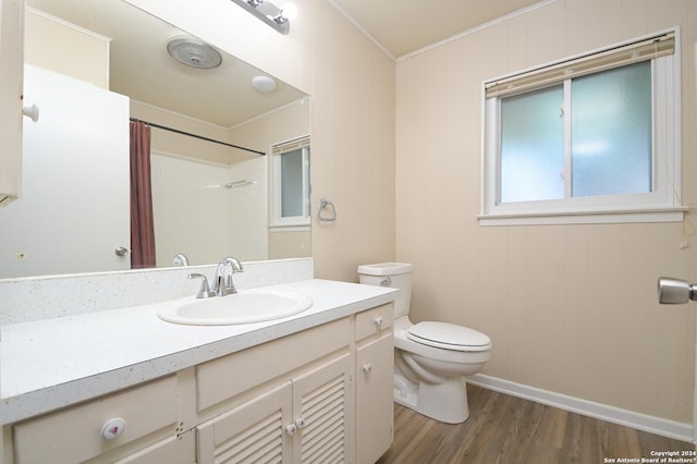 bathroom featuring a shower with shower curtain, ornamental molding, vanity, hardwood / wood-style floors, and toilet