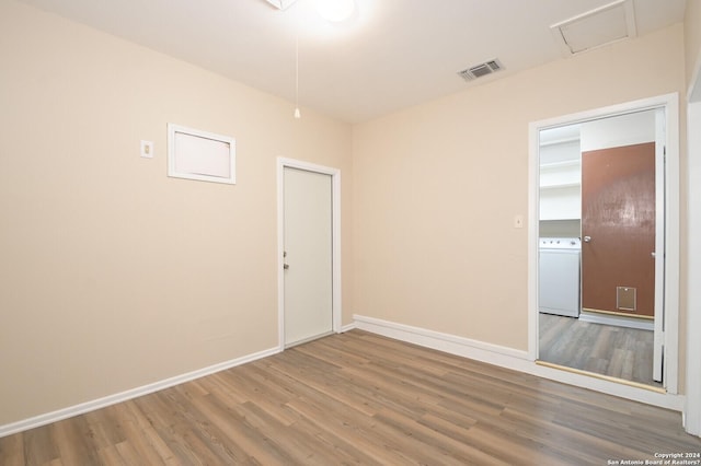 empty room with hardwood / wood-style flooring and washer / clothes dryer