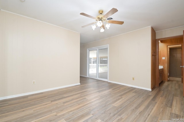 spare room with ceiling fan, crown molding, and light wood-type flooring