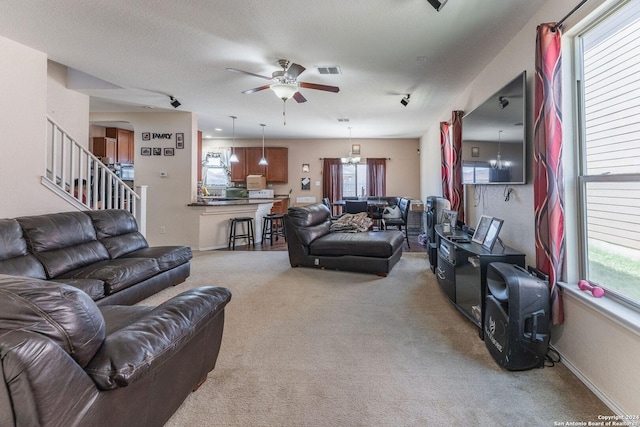 living room with ceiling fan, a textured ceiling, and carpet flooring