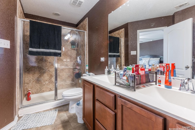 bathroom with toilet, a textured ceiling, walk in shower, tile patterned flooring, and vanity