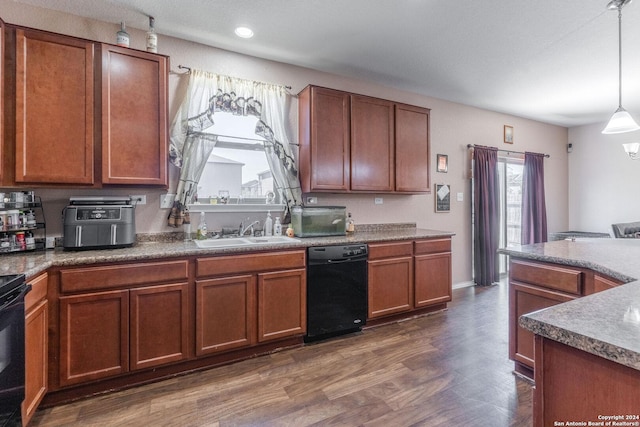 kitchen with black appliances, dark hardwood / wood-style floors, pendant lighting, and sink