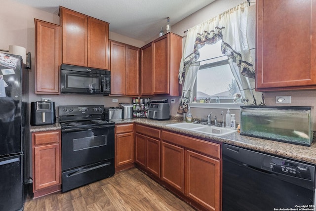 kitchen featuring sink, a textured ceiling, dark hardwood / wood-style floors, and black appliances