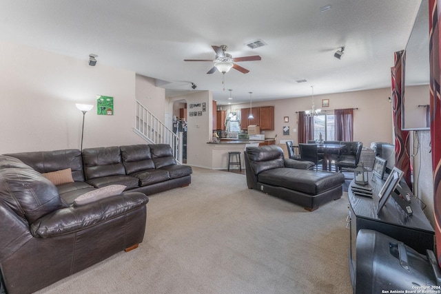 living room featuring light carpet and ceiling fan with notable chandelier