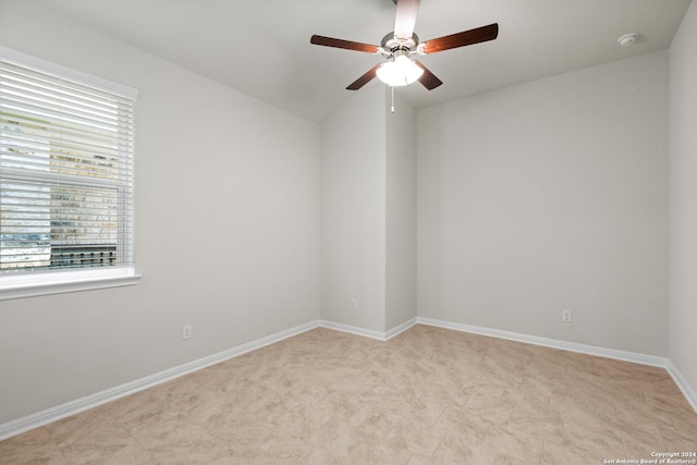 unfurnished room with ceiling fan, a wealth of natural light, and vaulted ceiling