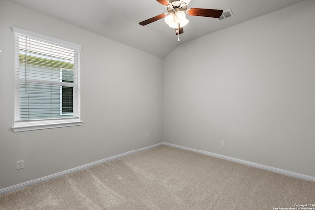 empty room with ceiling fan, carpet floors, and vaulted ceiling