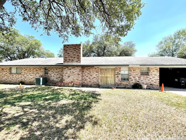 view of front facade with a front lawn, a garage, and cooling unit