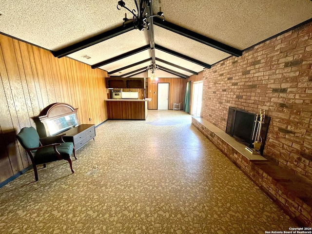 unfurnished living room featuring a brick fireplace, wood walls, and a textured ceiling