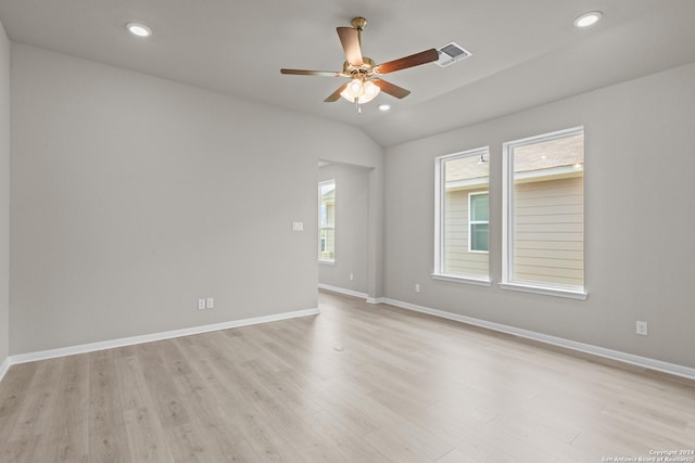 empty room featuring lofted ceiling, ceiling fan, and light wood-type flooring