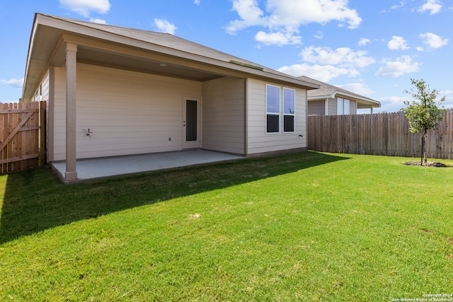 back of property with a yard and a patio area