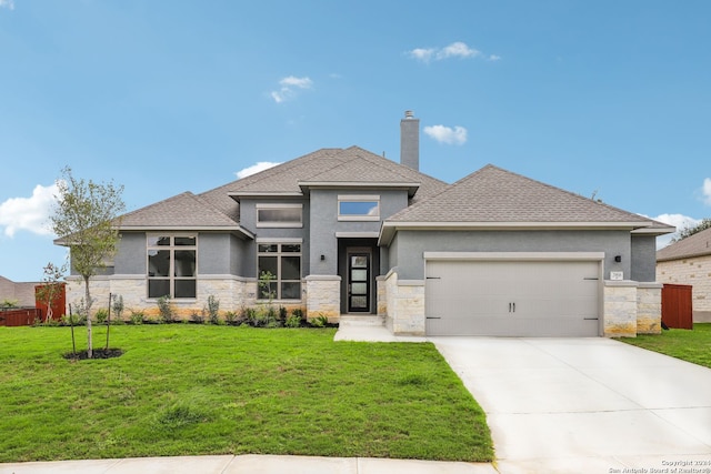 prairie-style home featuring a garage and a front yard