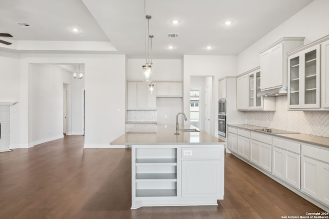 kitchen with sink, appliances with stainless steel finishes, a kitchen island with sink, hanging light fixtures, and white cabinetry