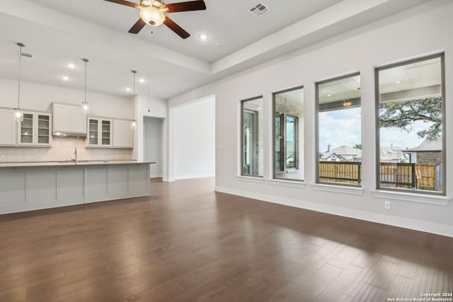 unfurnished living room featuring ceiling fan, dark hardwood / wood-style floors, and sink