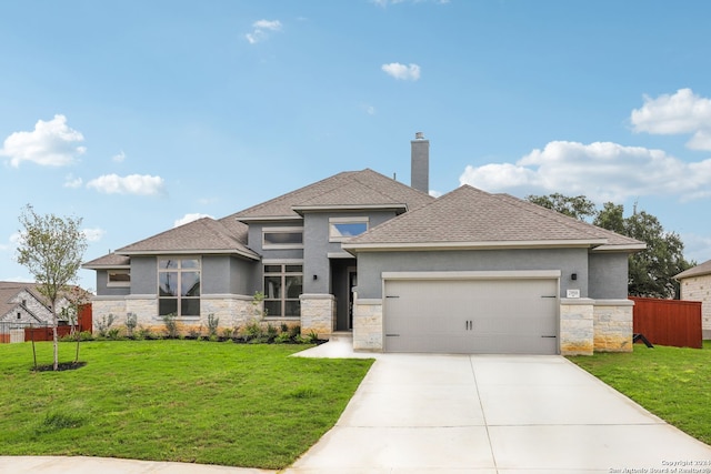 prairie-style home featuring a garage and a front yard