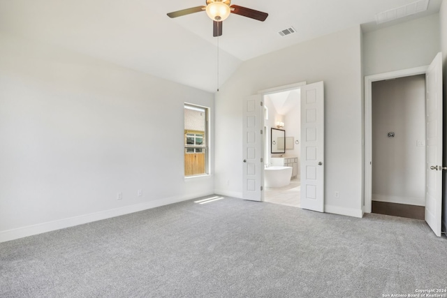 unfurnished bedroom featuring connected bathroom, vaulted ceiling, light colored carpet, and ceiling fan