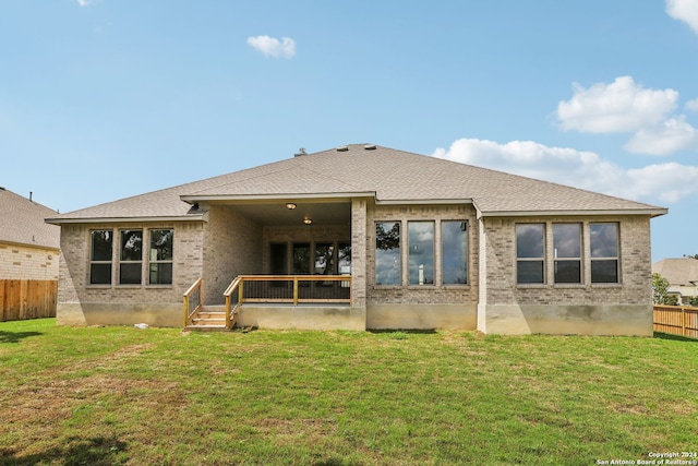 rear view of property featuring a lawn