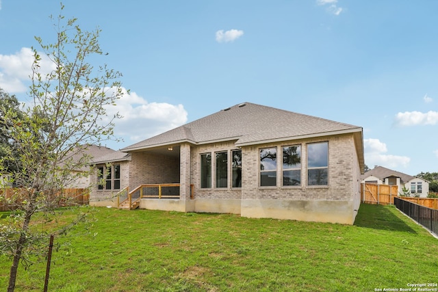 rear view of property with a lawn