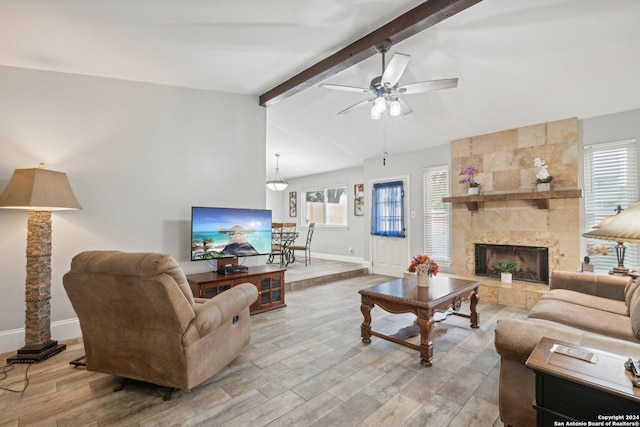 living room featuring ceiling fan, lofted ceiling with beams, and a fireplace