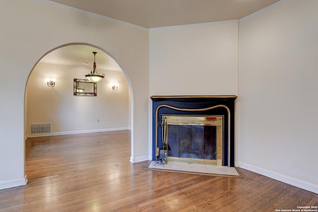 unfurnished living room featuring crown molding and hardwood / wood-style floors