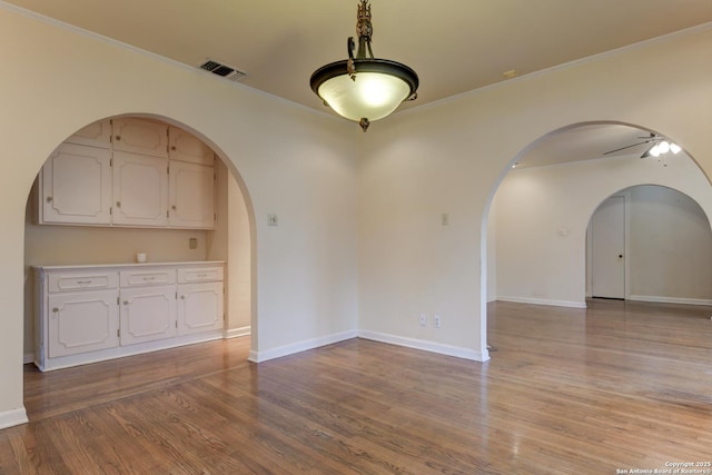 unfurnished room featuring light hardwood / wood-style floors, crown molding, and ceiling fan