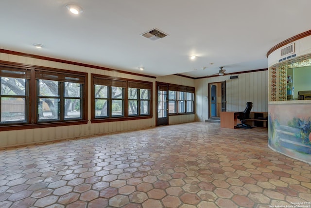 unfurnished living room featuring ceiling fan and ornamental molding