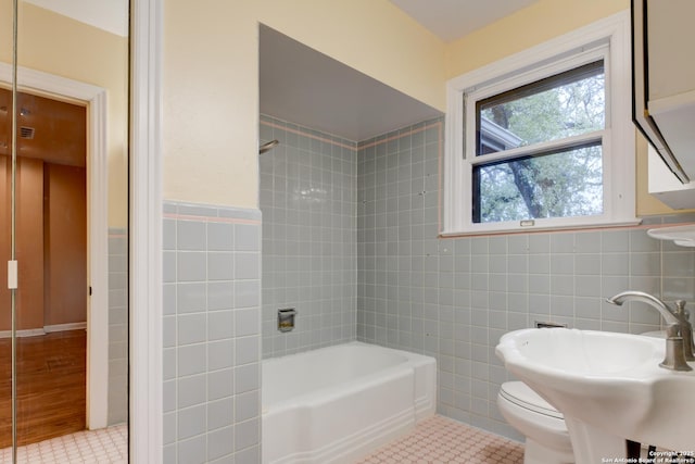 full bathroom featuring toilet, tile patterned floors, and tile walls