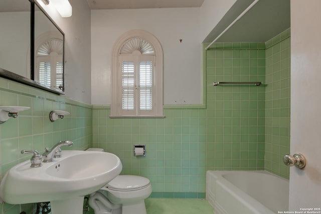 full bathroom with sink, toilet, shower with separate bathtub, and tile walls