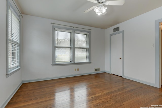 empty room with ceiling fan and dark hardwood / wood-style flooring